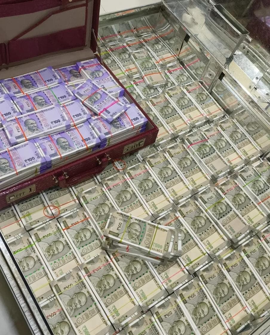Stacks of Indian 100 and 500 rupee banknotes packed in a red briefcase and safe.